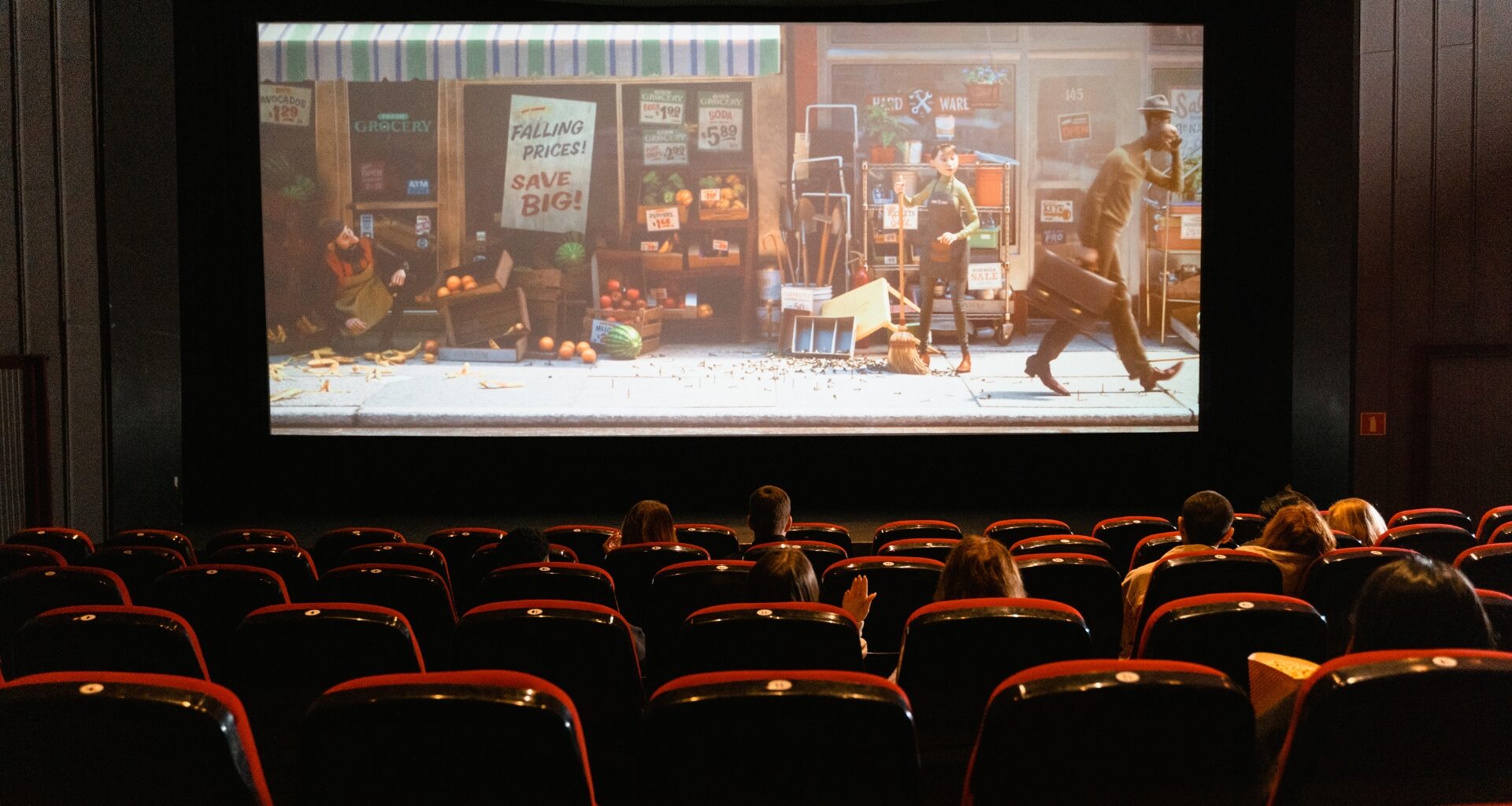 Widzowie oglądający film animowany na dużym ekranie w sali kinowej.