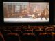 Widzowie oglądający film animowany na dużym ekranie w sali kinowej.